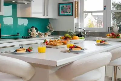 a kitchen with a breakfast table with fruit and juice at 3 Bed in Padstow oc-p00797 in Padstow