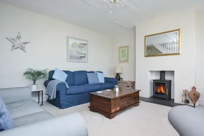 a living room with a blue couch and a fireplace at 3 Bed in Praa Sands oc-p00859 in Praa Sands