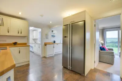 a kitchen with a stainless steel refrigerator in the middle at 4 Bed in Trevone oc-p00863 in Padstow