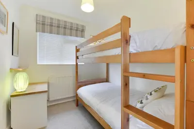 a bedroom with two bunk beds and a desk at 4 Bed in Trevone oc-p00863 in Padstow