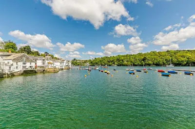 a group of boats in a river with houses at 3 Bed in Fowey oc-p00871 in Fowey
