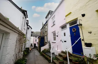 a narrow alley with white houses and blue doors at 3 Bed in Fowey oc-p00871 in Fowey