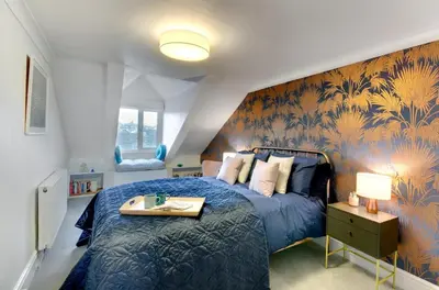 a bedroom with a blue bed with a blue patterned wall at 2 Bed in Fowey oc-p00873 in Fowey
