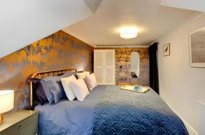 a bedroom with a bed with a blue comforter at 2 Bed in Fowey oc-p00873 in Fowey