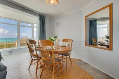 a dining room with a table and chairs and a mirror at 3 Bed in Porthleven oc-p00877 in Porthleven