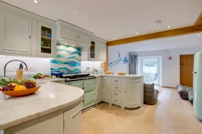 a kitchen with white cabinets and a bowl of fruit on a counter at 3 Bed in Padstow oc-p00807 in Padstow