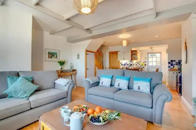 a living room with two couches and a table at 3 Bed in Gorran Haven oc-p00812 in Gorran Haven