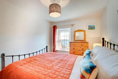 a bedroom with a bed and a dresser and a mirror at 3 Bed in Gorran Haven oc-p00812 in Gorran Haven