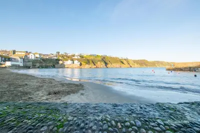 a beach with people swimming in the water at 3 Bed in Gorran Haven oc-p00812 in Gorran Haven