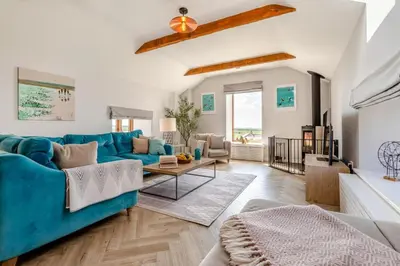 a living room with a blue couch and a table at 3 Bed in Mawgan Porth oc-p00824 in Mawgan Porth