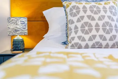 a bed with a pillow and a lamp on a table at 3 Bed in Mawgan Porth oc-p00824 in Mawgan Porth