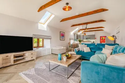 a living room with a blue couch and a tv at 3 Bed in Mawgan Porth oc-p00824 in Mawgan Porth