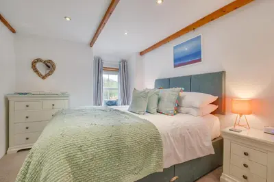 a bedroom with a large bed and a window at 2 Bed in Talskiddy oc-p00844 in Saint Columb Major