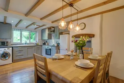 a kitchen with a wooden table with chairs and a dining room at 2 Bed in Talskiddy oc-p00844 in Saint Columb Major