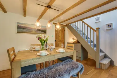 a dining room with a wooden table and a staircase at 2 Bed in Talskiddy oc-p00844 in Saint Columb Major