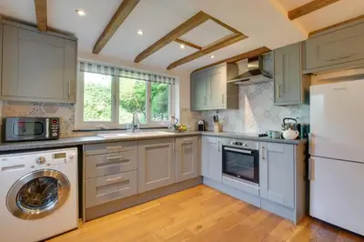 a kitchen with white cabinets and a washer and dryer at 2 Bed in Talskiddy oc-p00844 in Saint Columb Major