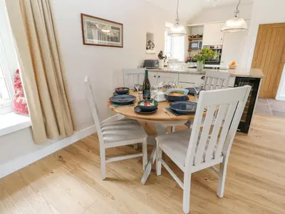 a kitchen and dining room with a wooden table and chairs at Gilly Skyber in Helston