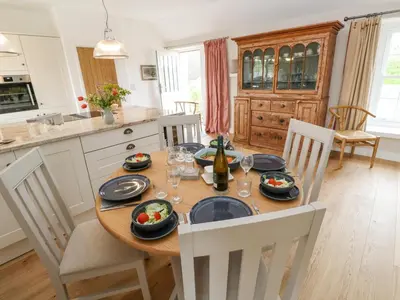 a kitchen with a wooden table with chairs and a dining room at Gilly Skyber in Helston