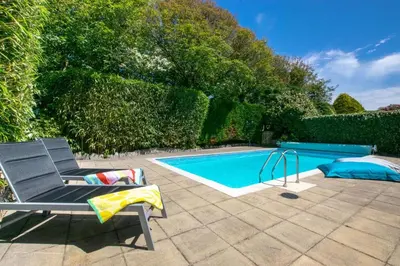 a swimming pool with a chair next to a swimming pool at 7 Bed in Ashton oc-p00891 in Germoe