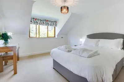 a white bedroom with a large bed and a desk at 7 Bed in Ashton oc-p00891 in Germoe