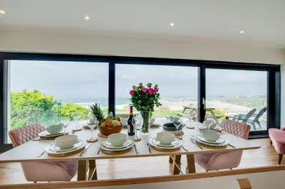 a dining room table with chairs and a large window at 5 Bed in Newquay oc-p00894 in Newquay
