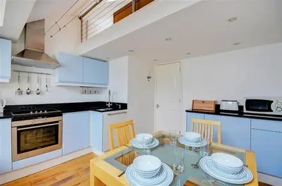 a kitchen with blue cabinets and a glass table with chairs at 1 Bed in St. Ives oc-pc1010 in St Ives