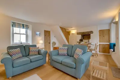 a living room with two blue chairs and a staircase at 2 Bed in Porthleven oc-pevcot in Porthleven
