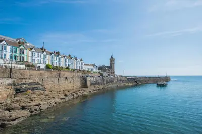 a river with houses and a boat in the water at 2 Bed in Porthleven oc-pevcot in Porthleven