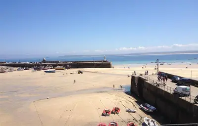 a beach with a group of people and the ocean at 2 Bed in St Ives oc-pc055a in St Ives