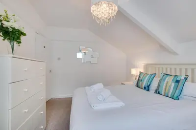 a bedroom with a white bed with a chandelier at 2 Bed in St Ives oc-pc055a in St Ives
