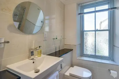 a bathroom with a sink and a toilet and a mirror at 2 Bed in Fowey oc-pont in Fowey