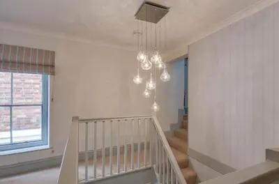 a white staircase with a chandelier in a room at 2 Bed in Fowey oc-pont in Fowey