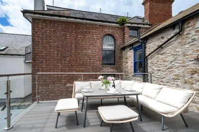 a patio with a table and chairs on a balcony at 2 Bed in Fowey oc-pont in Fowey