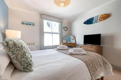 a bedroom with a large white bed and a flat screen tv at 2 Bed in Fowey oc-pont in Fowey