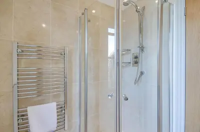a bathroom with a shower with a glass door at 2 Bed in Fowey oc-pont in Fowey