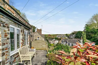 a patio with a white chair and a building at 2 Bed in Wadebridge oc-r27444 in Little Petherick