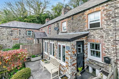a brick house with a bench in front of it at 2 Bed in Wadebridge oc-r27444 in Little Petherick