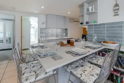 a kitchen with a table with chairs and wine glasses at 2 Bed in St. Ives oc-pc446c in St Ives