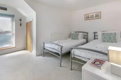 a bedroom with two beds and a chair at 2 Bed in St. Ives oc-pc446c in St Ives