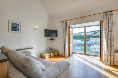 a living room with a couch and a large window at 2 Bed in Porthleven oc-quaysi in Porthleven