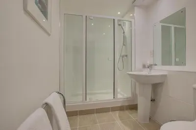 a white bathroom with a shower and a sink at 2 Bed in Porthleven oc-quaysi in Porthleven
