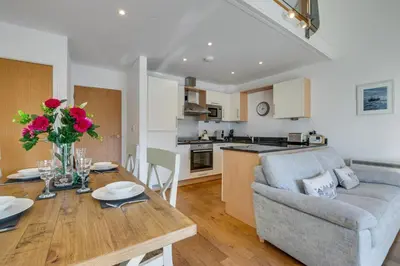 a kitchen and living room with a table and a couch at 2 Bed in Porthleven oc-quaysi in Porthleven
