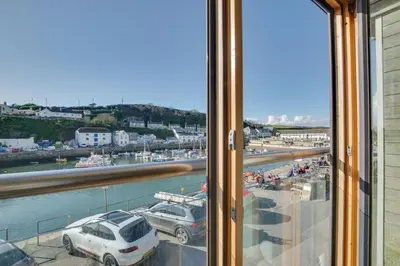 a window with a view of a harbor with cars at 2 Bed in Porthleven oc-quaysi in Porthleven