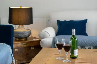 two glasses of wine on a table in a living room at 4 Bed in Polruan oc-scroft in Fowey