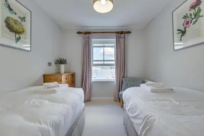 two beds in a room with a window at 4 Bed in Polruan oc-scroft in Fowey