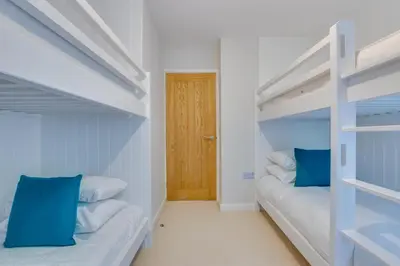 a bedroom with two bunk beds with blue pillows at 4 Bed in Polruan oc-scroft in Fowey