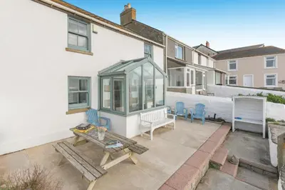 a patio with a bench and a table at 4 Bed in Porthleven oc-samcot in Porthleven