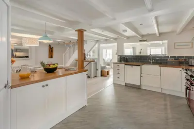 a large kitchen with white cabinets and a counter at 4 Bed in Porthleven oc-samcot in Porthleven