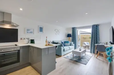 a kitchen and living room with a blue couch at 1 Bed in Porthleven oc-portb in Porthleven