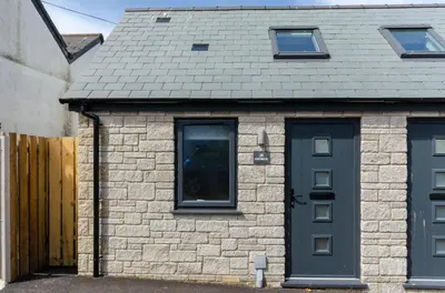 a brick house with a gray roof and two windows at 1 Bed in Porthleven oc-portb in Porthleven